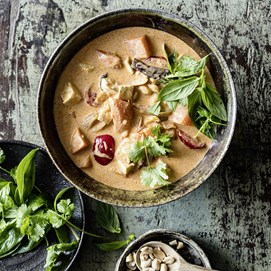 Buchcover „Deftig Vegan Asien“ mit großer Suppenschale, Essstäbchen und grünem Getränk auf dunklem Hintergrund.