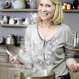 Buchcover mit Titel „Kochen ist die beste Medizin“, Autorin hält Teller mit Suppe, Mütze auf dem Kopf.