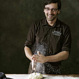Buchcover „Brot backen in Perfektion mit Hefe“ mit Brotfotos und Porträt von Lutz Geißler auf dunklem Hintergrund.