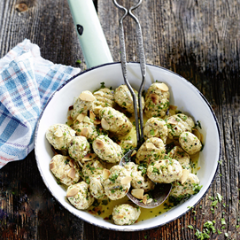 Buchcover „Easy. Überraschend. Low Carb. Das große GU-Kochbuch“ mit Gnocchi auf Teller und Kräutern.