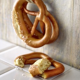 Buchcover „Brot backen in Perfektion mit Sauerteig“ mit Brotfotos, Gebäck und Porträt von Lutz Geißler.
