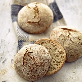 Buchcover „Brot backen in Perfektion mit Sauerteig“ mit Brotfotos, Gebäck und Porträt von Lutz Geißler.