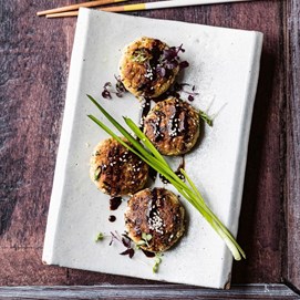 Buchcover „Deftig Vegan Asien“ mit großer Suppenschale, Essstäbchen und grünem Getränk auf dunklem Hintergrund.