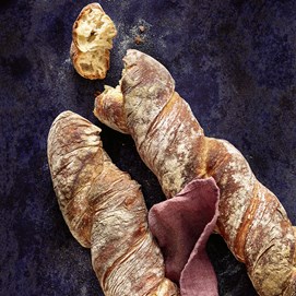 Buchcover „Die neue Brotbackformel“ von Lutz Geißler mit gelbem Hintergrund und Brotauswahl im Arm.