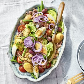 Buchcover „Patricia Kelly’s Family-Kochbuch“ mit Autorin in grünem Kleid und einer Quiche.