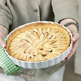 Buchcover „Patricia Kelly’s Family-Kochbuch“ mit Autorin in grünem Kleid und einer Quiche.