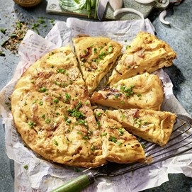 Buchcover „Patricia Kelly’s Family-Kochbuch“ mit Autorin in grünem Kleid und einer Quiche.